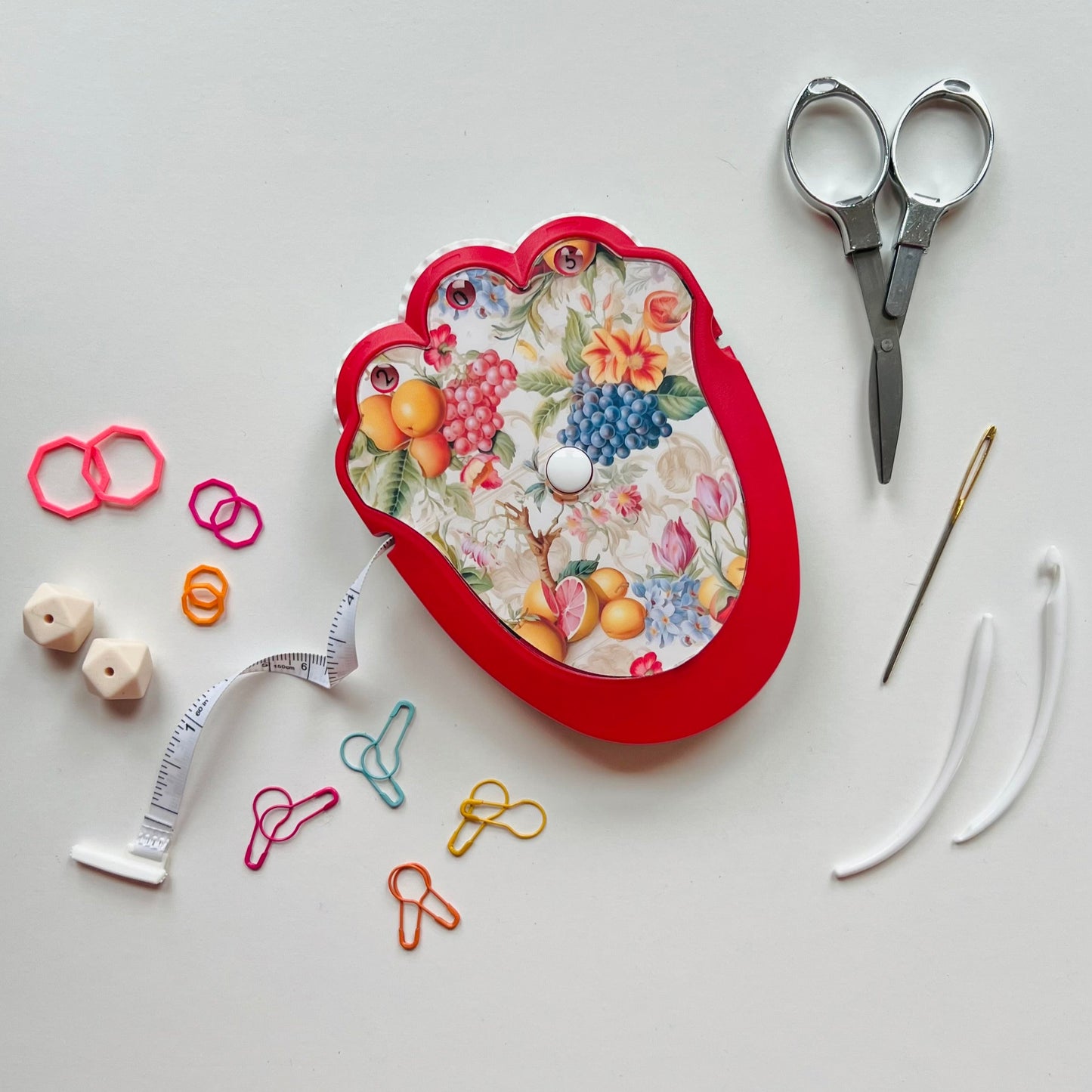 Knitting kit with scissors, thread, and pins on a white background