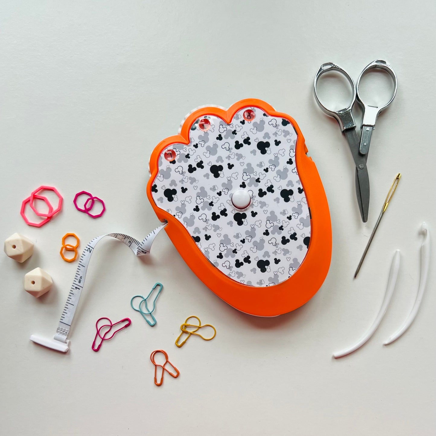 Knitting kit with scissors, thread, and pins on a light gray background