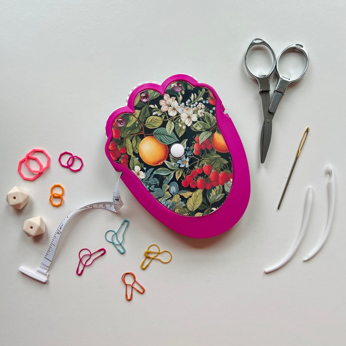 Pink knitting kit with floral design on a white background