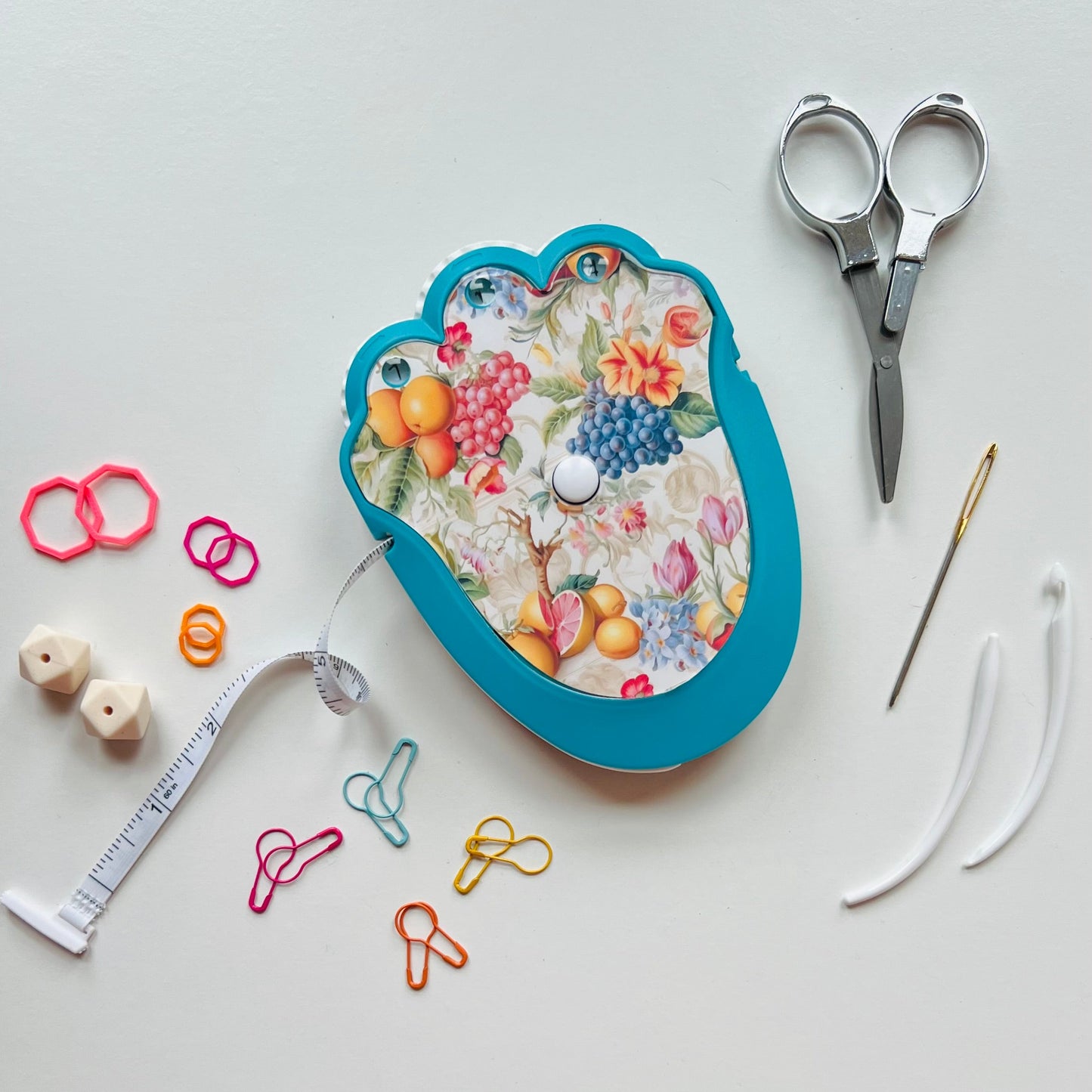 Knitting kit with scissors, thread, and measuring tape on a white background