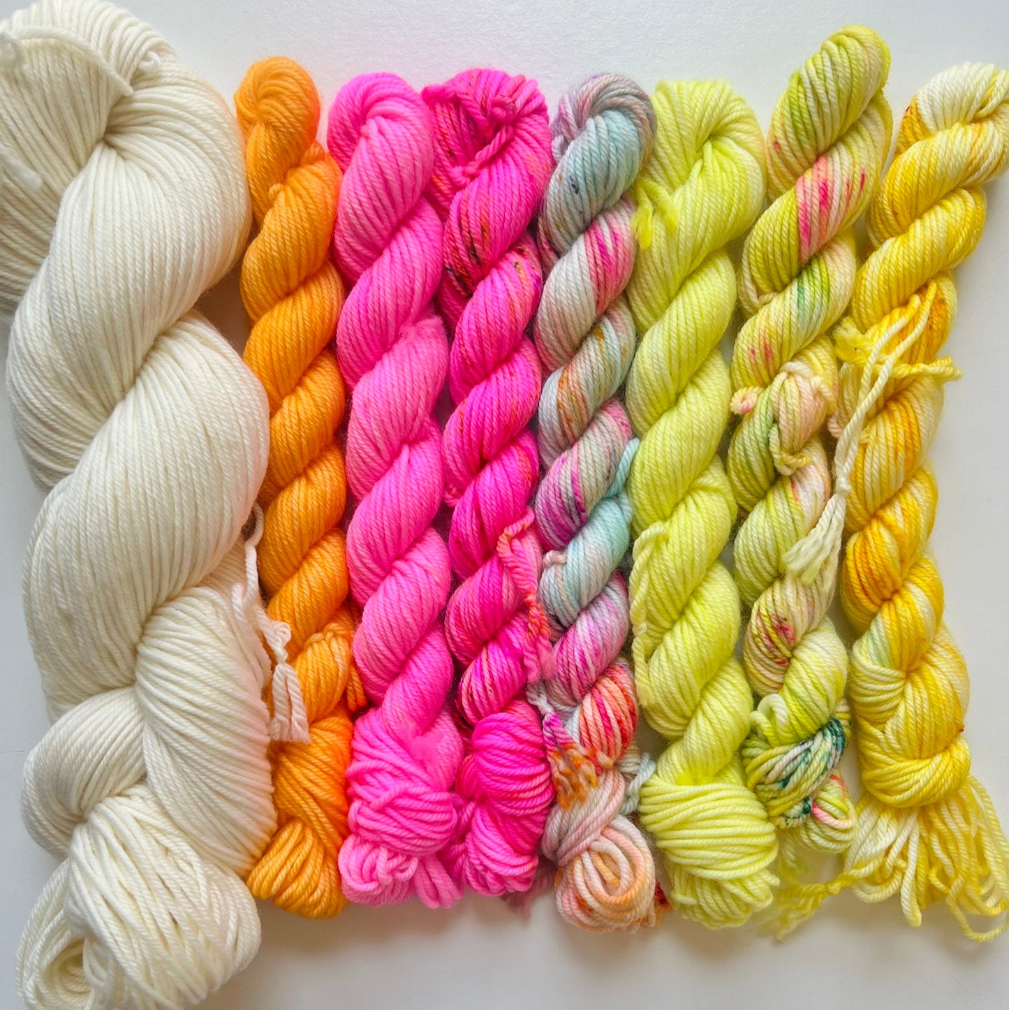 Colorful yarn skeins arranged on a white background