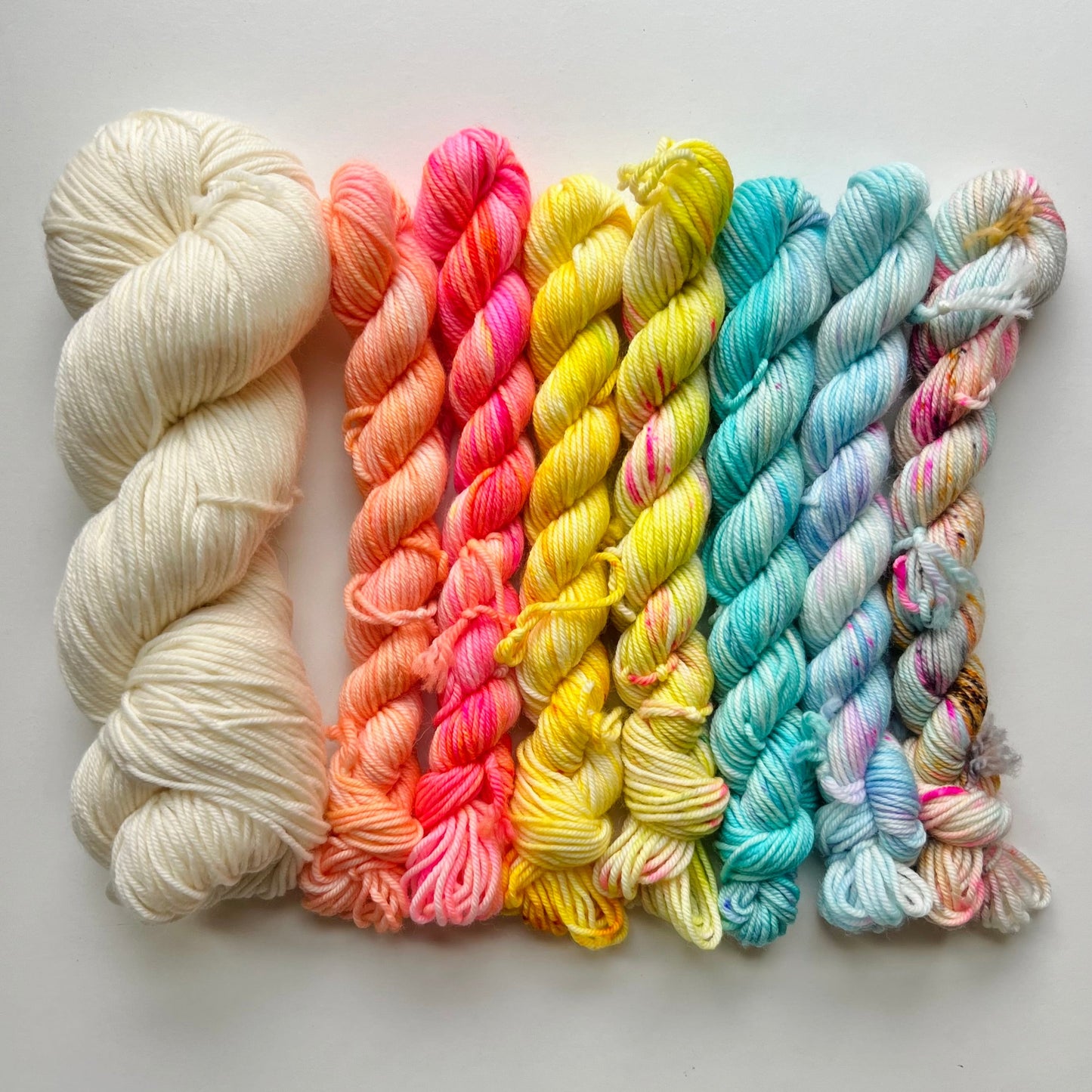 Set of colorful yarn skeins on a light gray background