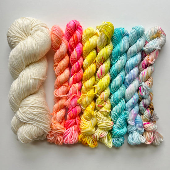Set of colorful yarn skeins on a light gray background