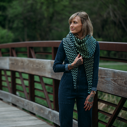Woman standing on a wooden bridge wearing a patterned scarf