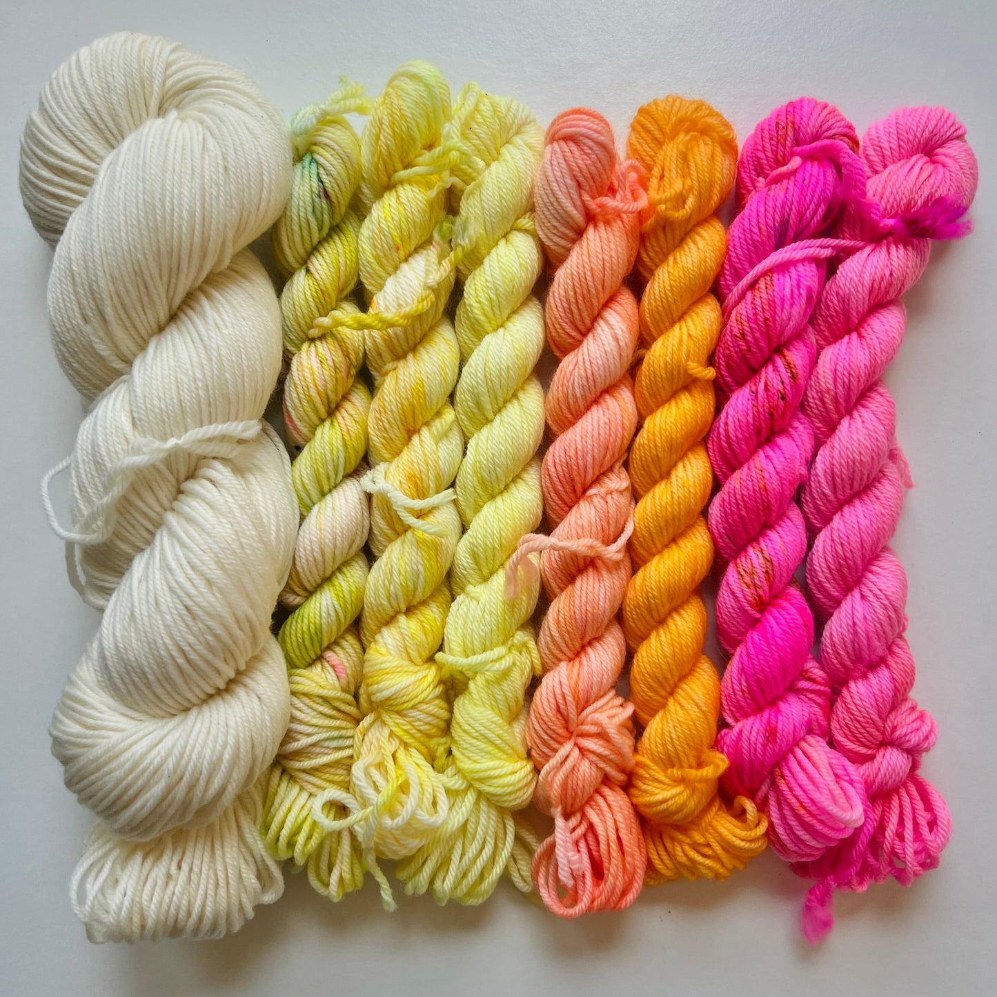 Set of colorful yarn skeins on a light gray background