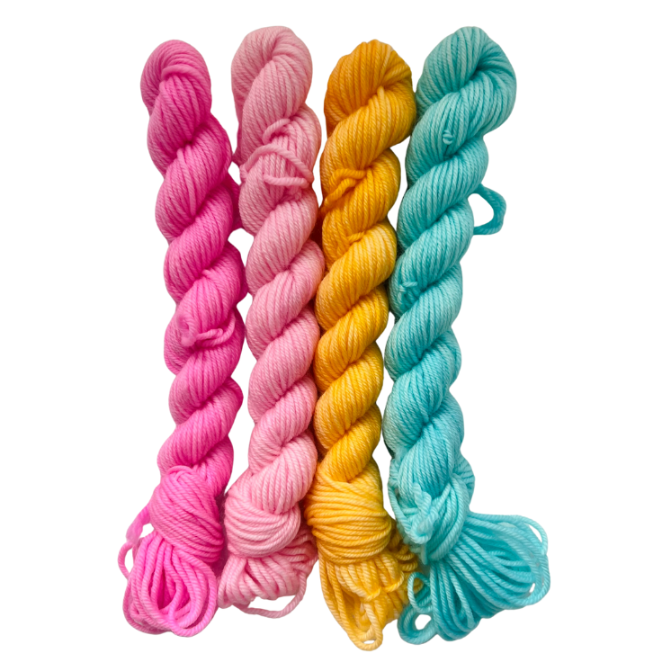 Three skeins of colorful yarn in pink, yellow, and blue on a white background
