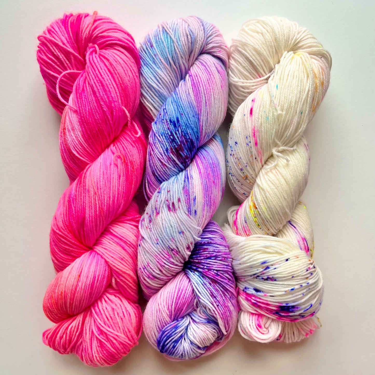 Three skeins of colorful yarn on a white background