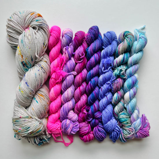 Colorful skeins of yarn arranged on a white background