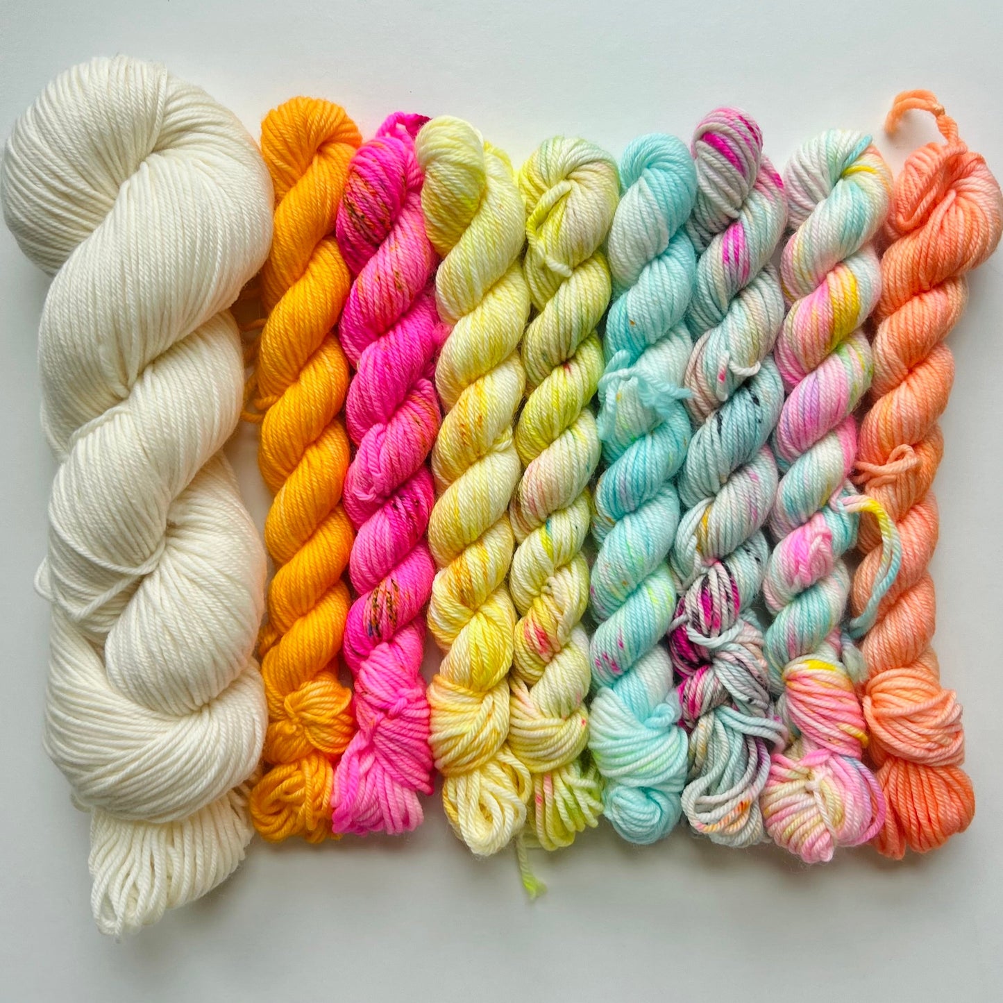 Set of colorful yarn skeins on a light gray background