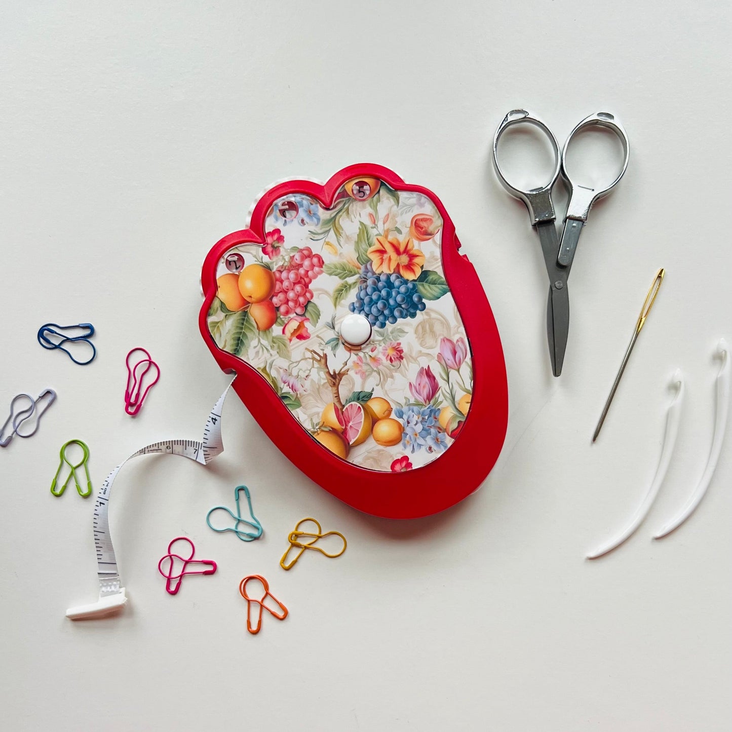 Decorative crocheting kit with scissors, pins, and a needle on a white background