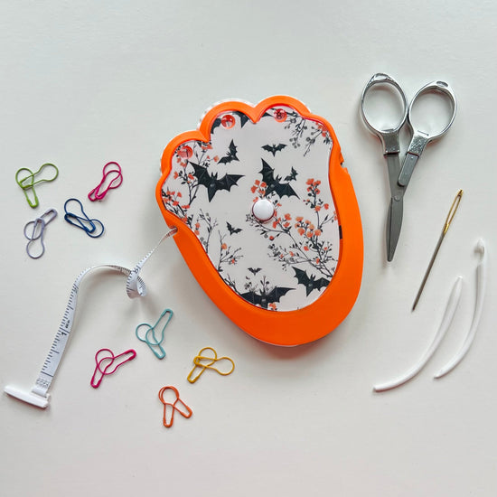 Decorative crocheting kit with scissors, thread, and pins on a light background