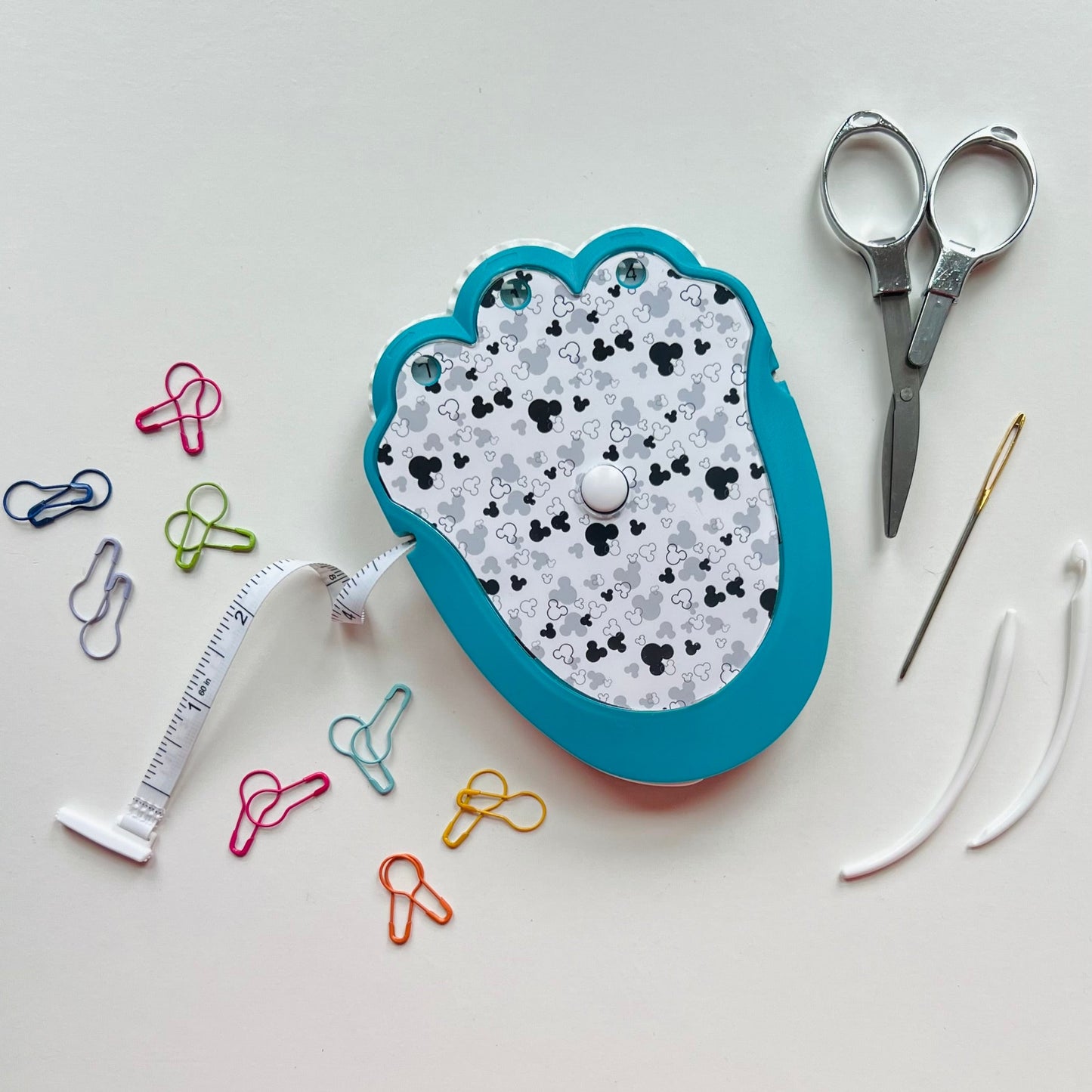 crocheting g kit with scissors, thread, and pins on a white background
