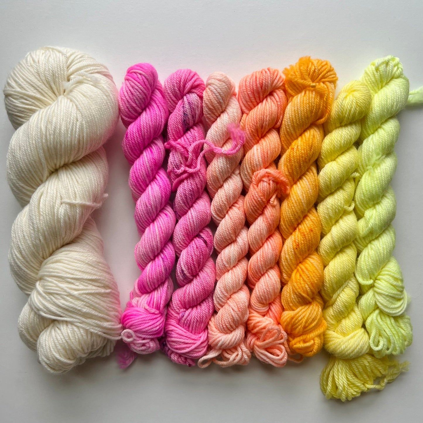 Set of colorful yarn skeins on a light gray background